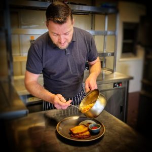 James Dempsey serving beans on toast